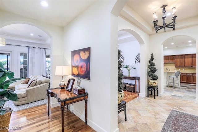 16649 Toscana Cir Unit 803, Naples, FL 34110 - hall featuring a tray ceiling, baseboards, a notable chandelier, and recessed lighting