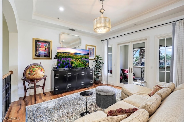 16649 Toscana Cir Unit 803, Naples, FL 34110 - living room with ornamental molding, arched walkways, a tray ceiling, and wood finished floors
