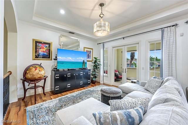 16649 Toscana Cir Unit 803, Naples, FL 34110 - living area featuring a raised ceiling, crown molding, wood finished floors, french doors, and a chandelier