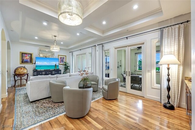 16649 Toscana Cir Unit 803, Naples, FL 34110 - living room with a raised ceiling, ornamental molding, arched walkways, french doors, and light wood-style floors