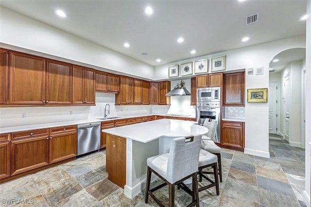 16649 Toscana Cir Unit 803, Naples, FL 34110 - kitchen featuring stainless steel appliances, arched walkways, backsplash, light countertops, and a kitchen bar