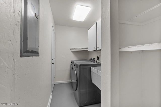 laundry area with cabinets, electric panel, and washer and clothes dryer