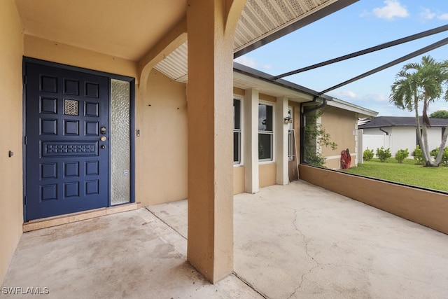 view of exterior entry with a patio area