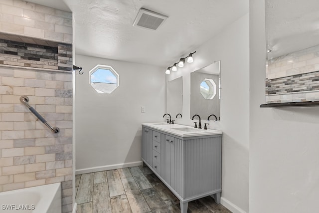 bathroom with vanity, shower / washtub combination, hardwood / wood-style floors, and a textured ceiling