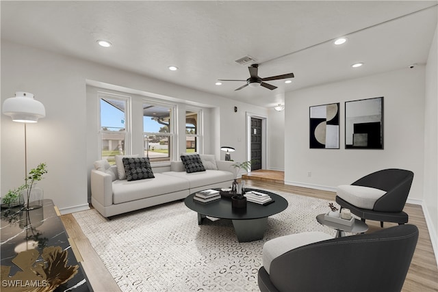 living room featuring ceiling fan and light hardwood / wood-style floors