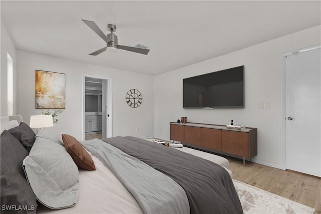 bedroom with ensuite bathroom, ceiling fan, and light wood-type flooring