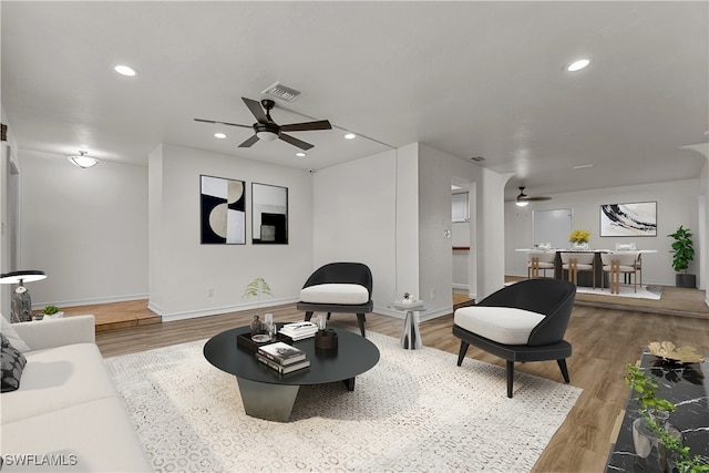 living room featuring wood-type flooring and ceiling fan