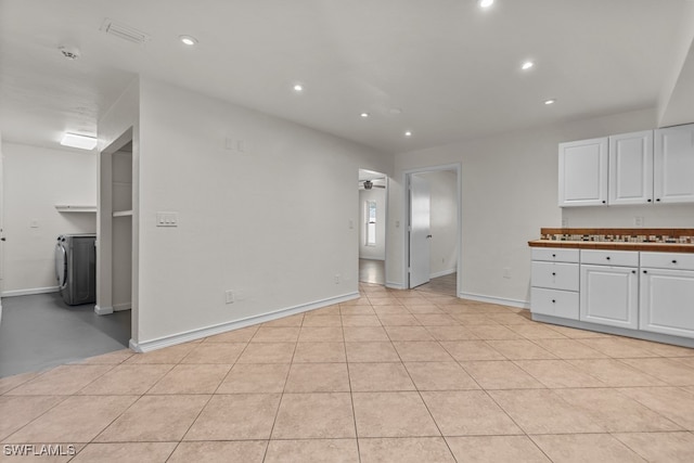 kitchen featuring white cabinetry, washer / dryer, and light tile patterned floors