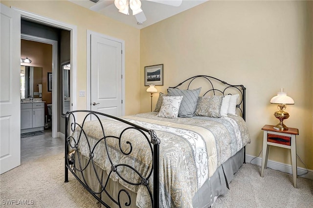 carpeted bedroom with ceiling fan, a closet, and ensuite bath