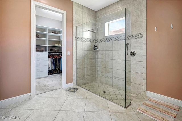 bathroom featuring tile patterned flooring and a tile shower