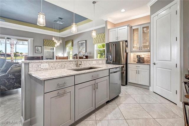 kitchen featuring appliances with stainless steel finishes, light stone counters, sink, gray cabinets, and hanging light fixtures