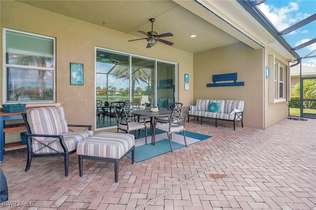 view of patio with an outdoor living space, a lanai, and a ceiling fan