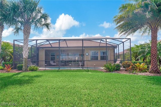 rear view of property featuring a lanai and a yard