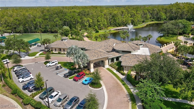 birds eye view of property featuring a water view and a wooded view