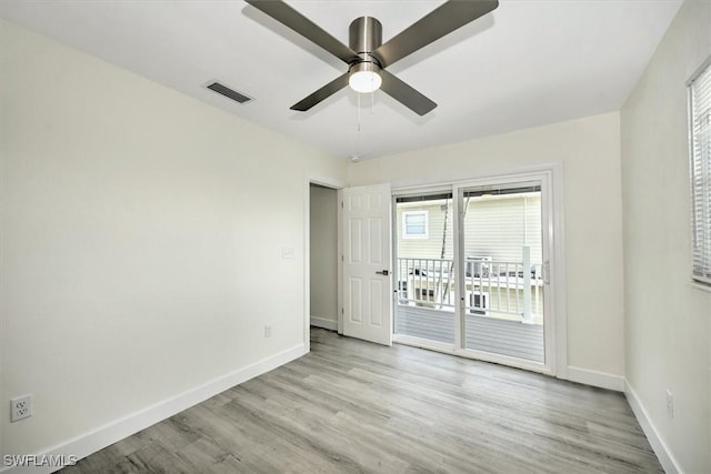 unfurnished room featuring ceiling fan, visible vents, baseboards, and wood finished floors