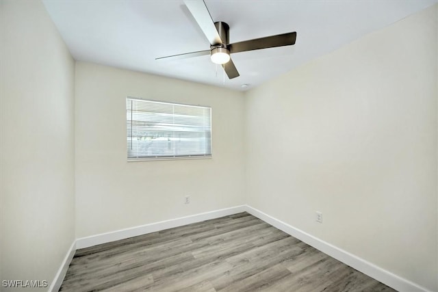 spare room featuring ceiling fan, baseboards, and wood finished floors