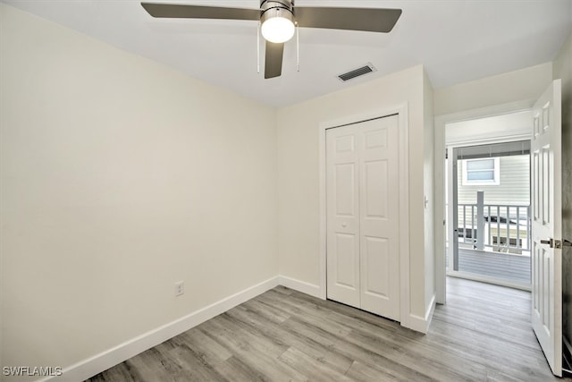 unfurnished bedroom with ceiling fan, a closet, and light wood-type flooring