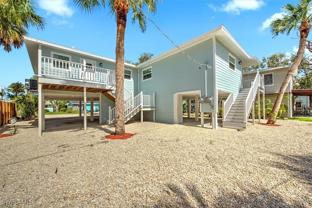 rear view of property with central AC unit and a carport