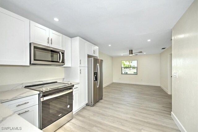 kitchen with appliances with stainless steel finishes, white cabinetry, light hardwood / wood-style flooring, and ceiling fan