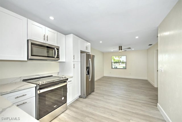 kitchen with appliances with stainless steel finishes, a ceiling fan, and white cabinetry