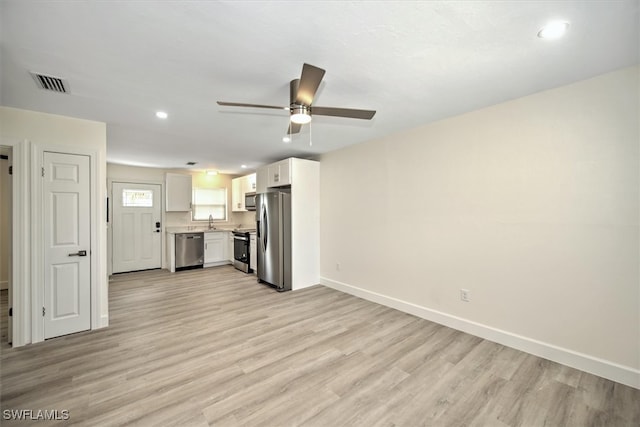 unfurnished living room featuring ceiling fan, sink, and light hardwood / wood-style flooring