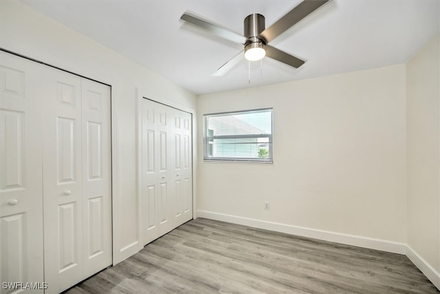 unfurnished bedroom featuring two closets, ceiling fan, and light hardwood / wood-style floors