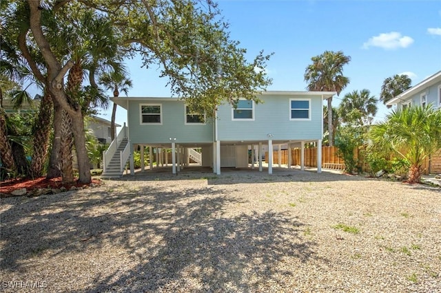 back of property with a carport, stairway, fence, and driveway