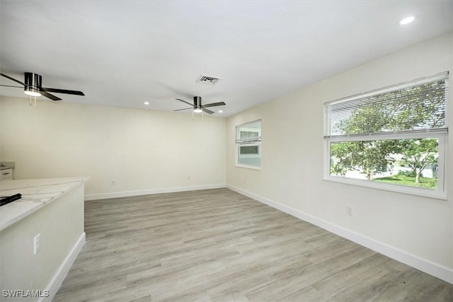 empty room with light wood finished floors, visible vents, recessed lighting, and baseboards