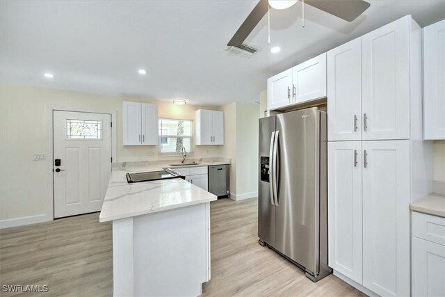 kitchen with white cabinetry, stainless steel appliances, light hardwood / wood-style flooring, and ceiling fan