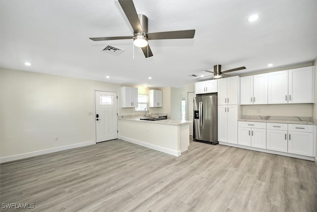 kitchen featuring white cabinets, light hardwood / wood-style floors, stainless steel fridge, kitchen peninsula, and ceiling fan