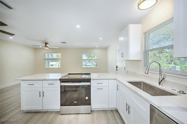 kitchen featuring white cabinetry, sink, light stone countertops, ceiling fan, and appliances with stainless steel finishes