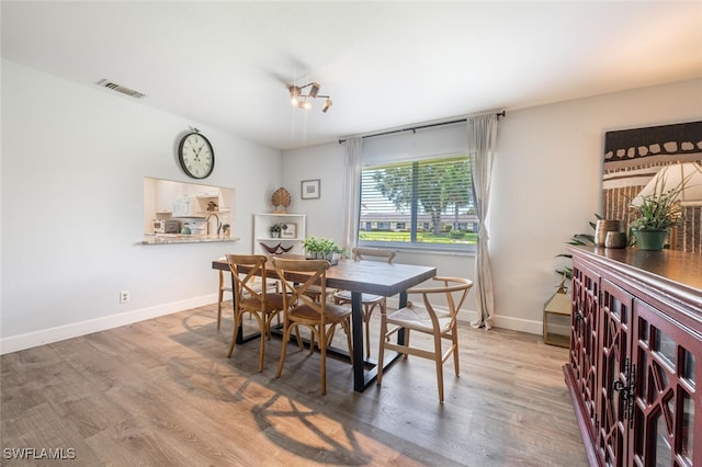 dining area with wood finished floors, baseboards, and visible vents