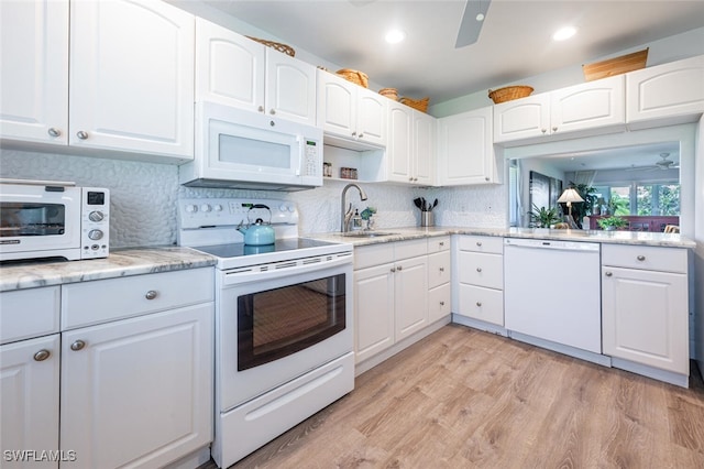 kitchen featuring white appliances, sink, white cabinetry, ceiling fan, and light wood-type flooring