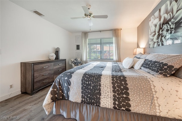 bedroom featuring baseboards, visible vents, wood finished floors, and a ceiling fan