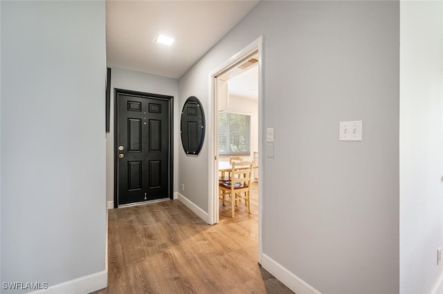 entryway featuring baseboards and light wood finished floors