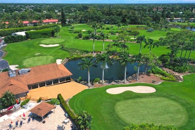birds eye view of property with golf course view and a water view