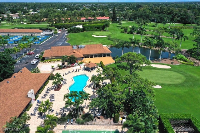 drone / aerial view with view of golf course and a water view