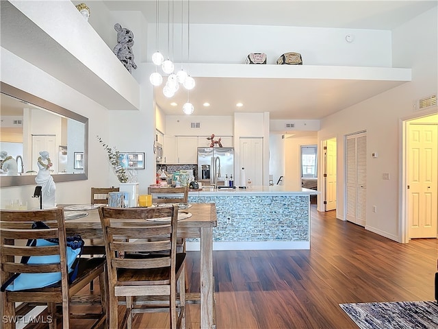 dining space with dark hardwood / wood-style floors and a chandelier