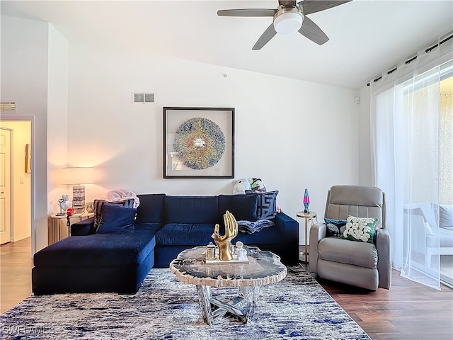 living room with lofted ceiling, ceiling fan, and wood-type flooring