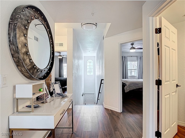 corridor with dark hardwood / wood-style floors and a textured ceiling