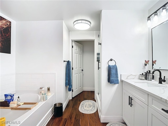 bathroom featuring vanity, hardwood / wood-style floors, and a bathtub