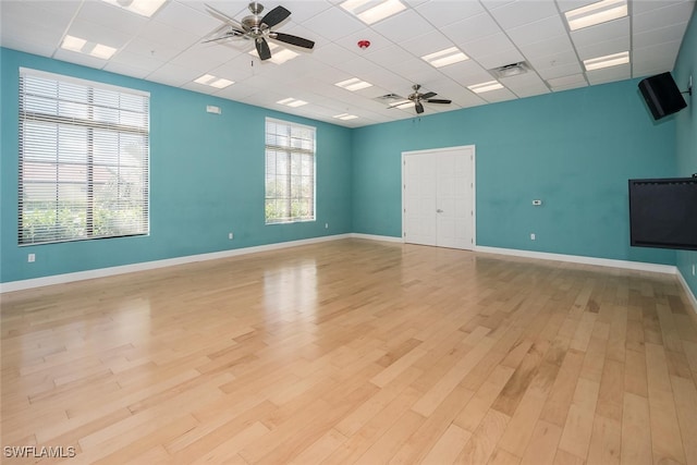 empty room featuring ceiling fan, light hardwood / wood-style floors, and a drop ceiling