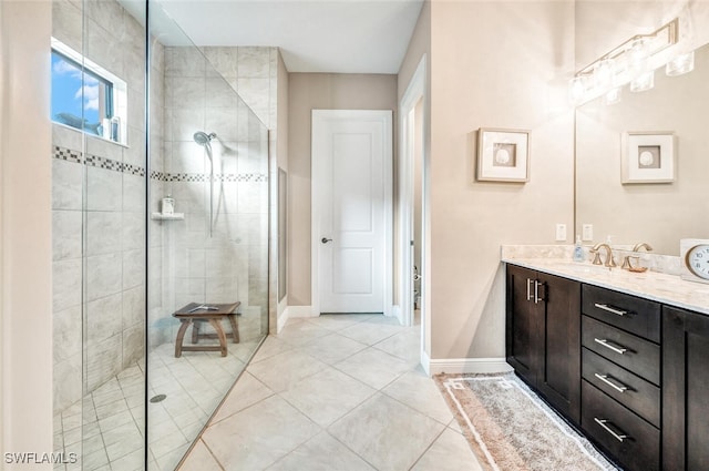 bathroom with vanity, tiled shower, and tile patterned floors