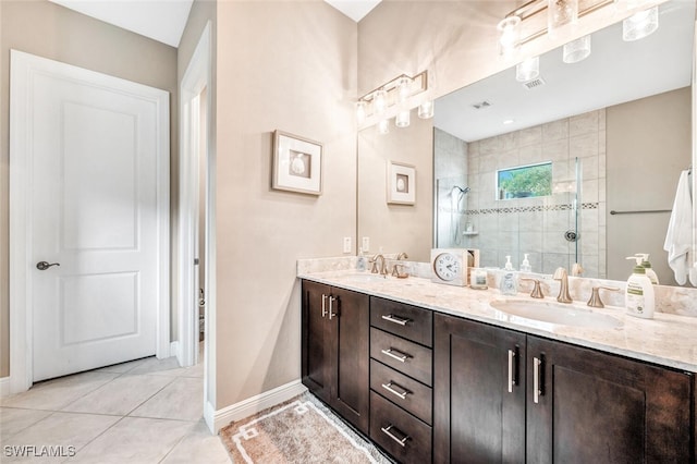 bathroom featuring vanity, tile patterned flooring, and a tile shower