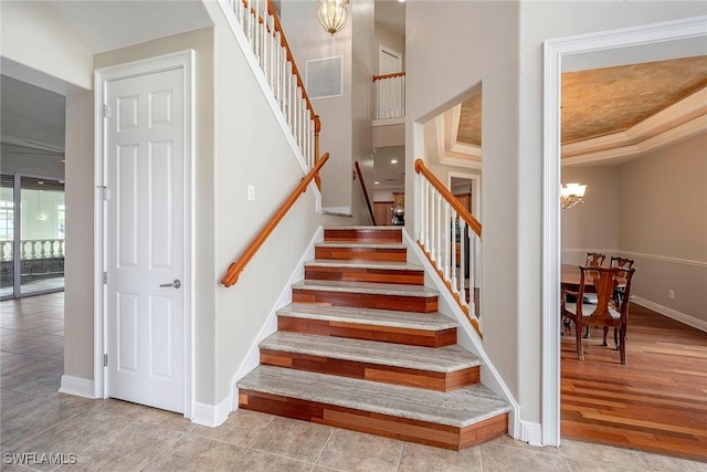 staircase with hardwood / wood-style floors and a chandelier