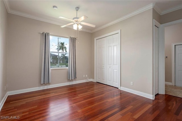 unfurnished bedroom with ceiling fan, ornamental molding, dark wood-type flooring, and a closet