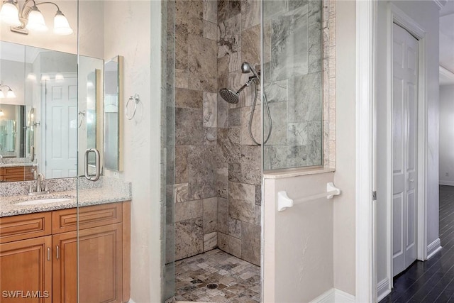 bathroom featuring a tile shower, vanity, and hardwood / wood-style flooring