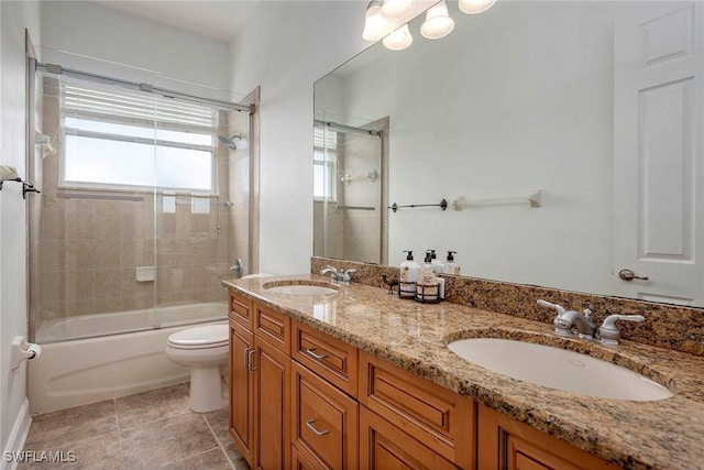 full bathroom with combined bath / shower with glass door, vanity, toilet, and tile patterned flooring