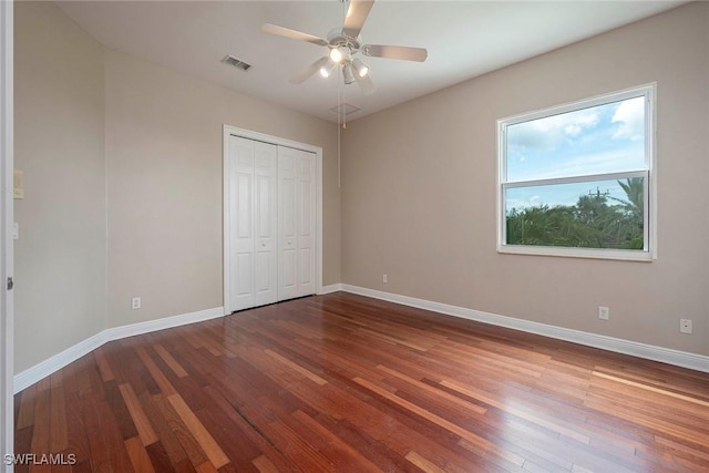 unfurnished bedroom featuring ceiling fan, a closet, and hardwood / wood-style flooring