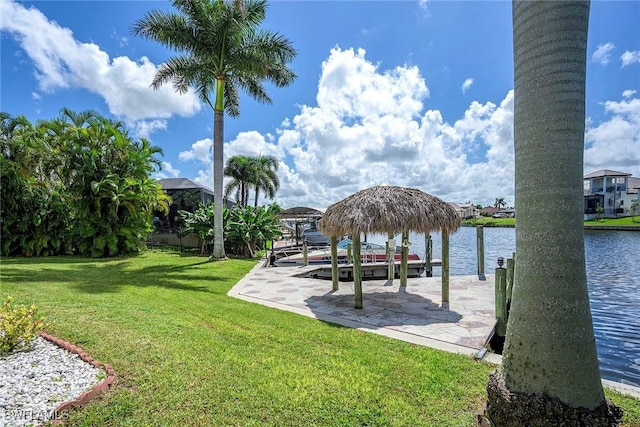 view of dock with a lawn and a water view